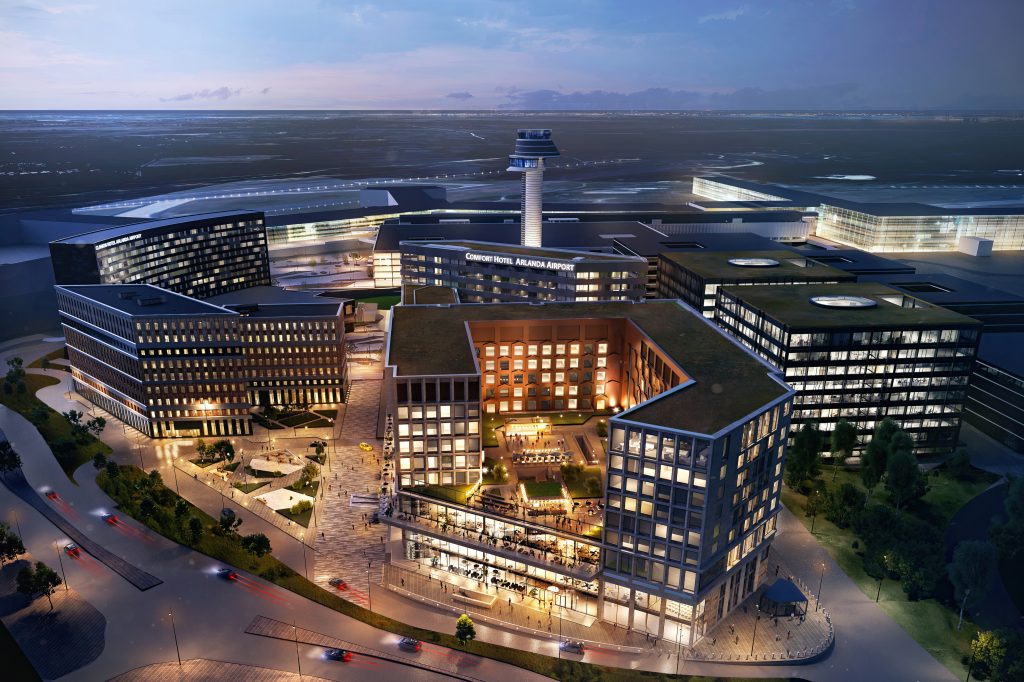 241106_NSW_05_night_utan_logga Rendering, nattbild. Hotell i fonden med uformad högdel på kvartersstor bottenvåning, flygledartorn och landningsbana i bakgrunden